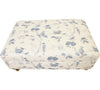 Large oblong footstool above view with sanderson woodland chorus fabric that has woodland scenery with birds in blue and cream with brass castor foot