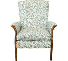  Parker Knoll Froxfield small chair with antique wooden front arms that swoop outwards and upholstered in teal coloured leafy fabric with a white backing.