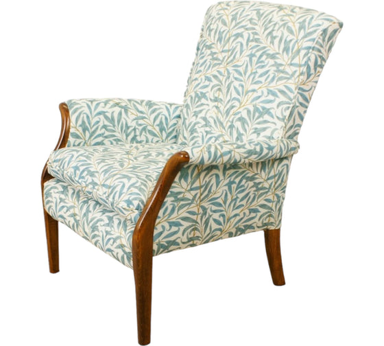 Parker Knoll Froxfield small chair with antique wooden front arms that swoop outwards and upholstered in teal coloured leafy fabric with a white backing.