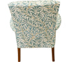 The outback view of the Parker Knoll Froxfield small chair with antique wooden front arms that swoop outwards and upholstered in teal coloured leafy fabric with a white backing.