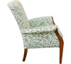 the side view of the Parker Knoll Froxfield small chair with antique wooden front arms that swoop outwards and sloped back frame with upholstery in teal coloured leafy fabric with a white backing.