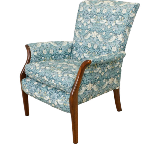 small chair with dark wood fronted arms upholstered in a repetitive busy fabric with birds and strawberries in a Teal colour 