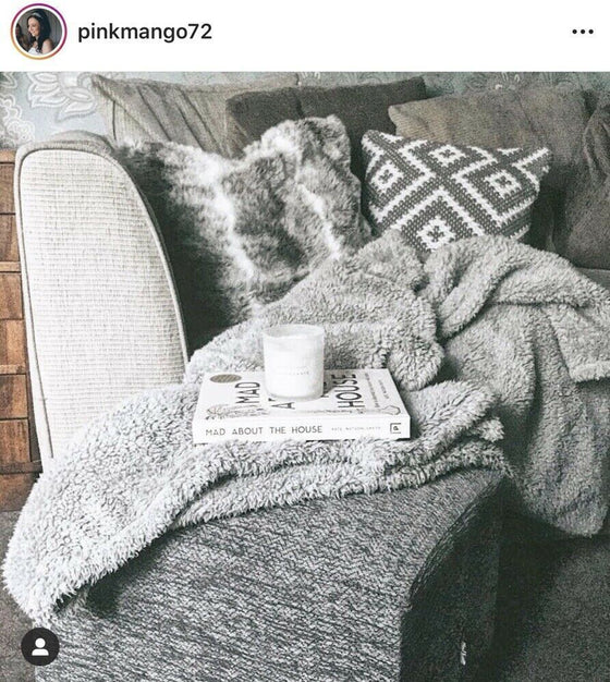 Styled imaged of a sofa, scatter cushions, Furry throw and our Herringbone Chenille footstool with a Book called the Mad about the house on top of it 