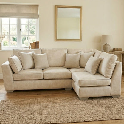 Beige sectional sofa in a living room with a mirror, lamp, and decor items.