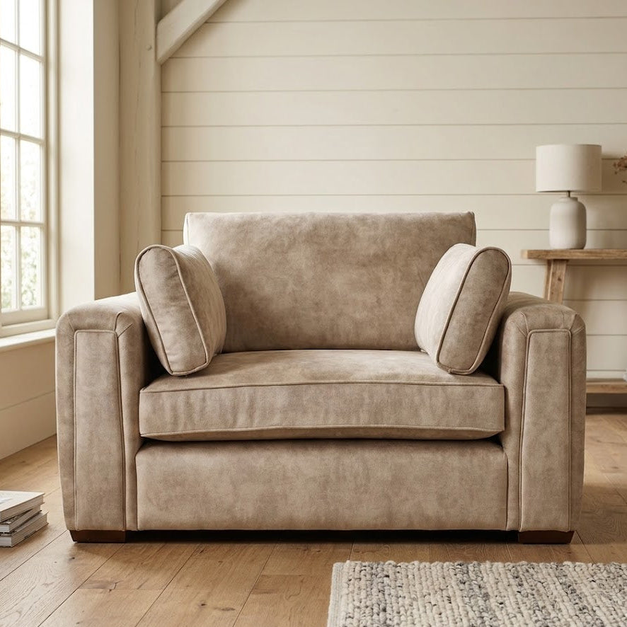 Beige armchair in a room with wooden flooring and a lamp in the background