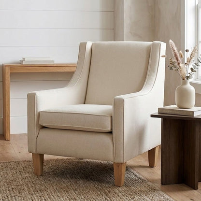 Beige armchair in a room with a desk and lamp