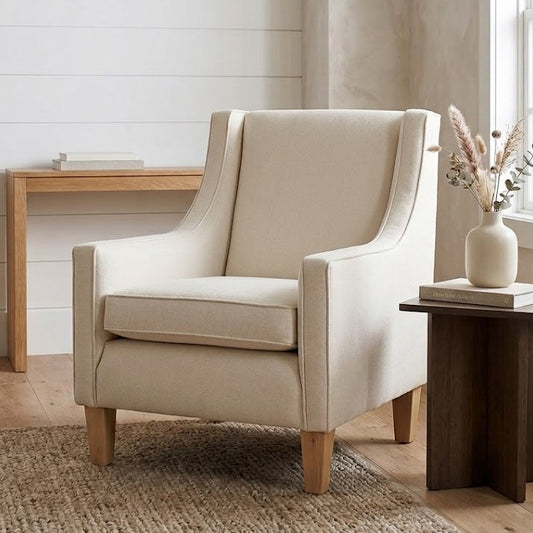 Beige armchair in a room with a desk and lamp