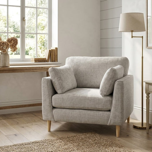 Gray armchair in a living room with wooden table and lamp