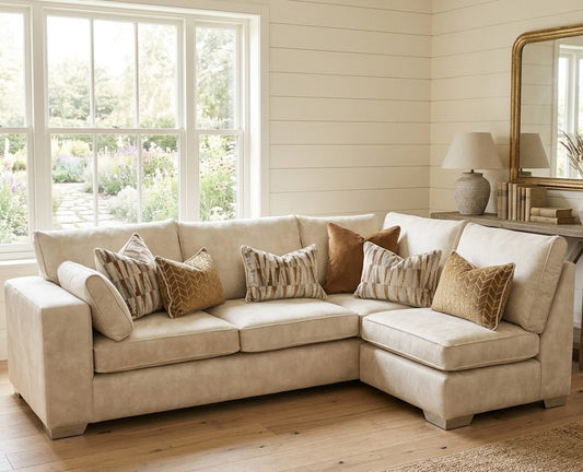 Beige sectional sofa with decorative pillows in a bright living room.
