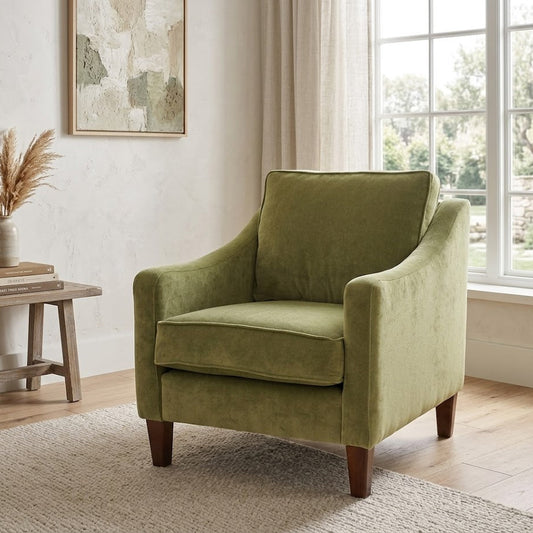 Green armchair in a room with a window and decorative elements.