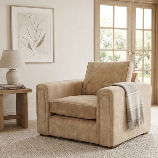 Beige armchair in a living room with a side table and lamp.