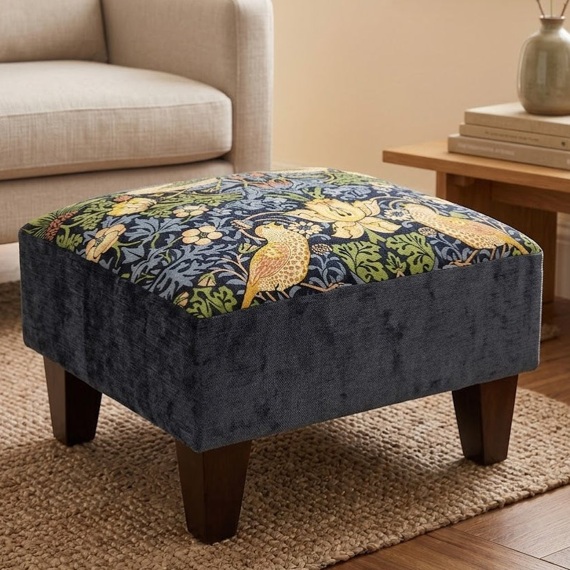 Patterned ottoman in a living room setting with a sofa and side table.