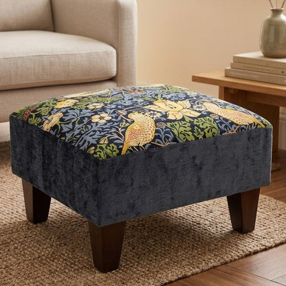 Patterned ottoman in a living room setting with a sofa and side table.