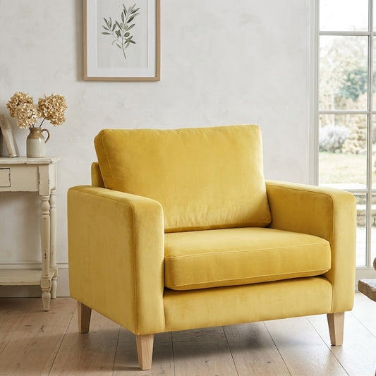Yellow armchair in a room with a window, table, and decorative items.