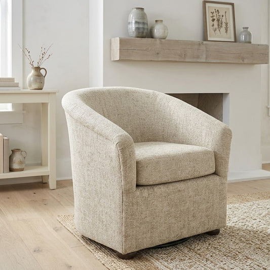 Beige armchair in a living room setting with a fireplace and wooden mantel.