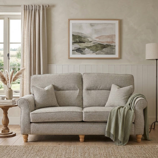 Gray sofa in a living room with a painting on the wall and a lamp.