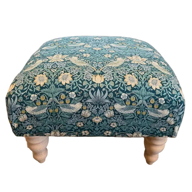 Patterned ottoman in a living room setting with furniture and decor.