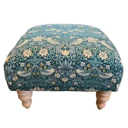 Patterned ottoman in a living room setting with furniture and decor.