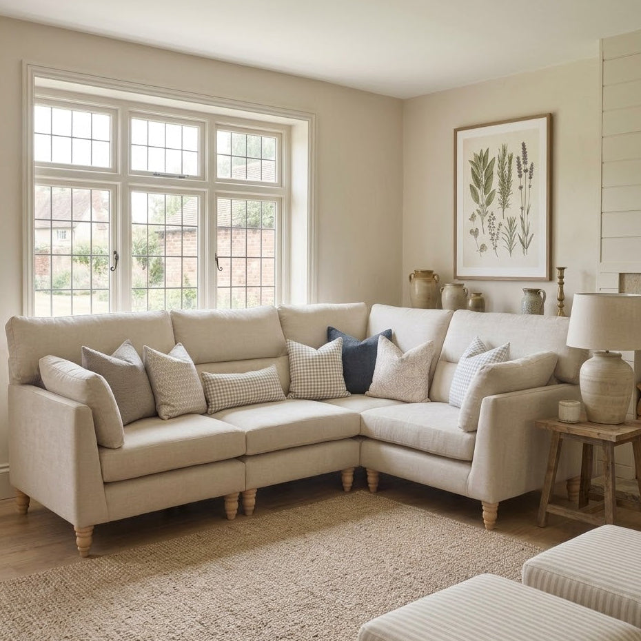 Cozy living room with a beige sectional sofa, decorative pillows, and a lamp.