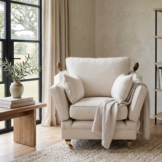 Beige armchair in a living room with a wooden coffee table and bookshelf.