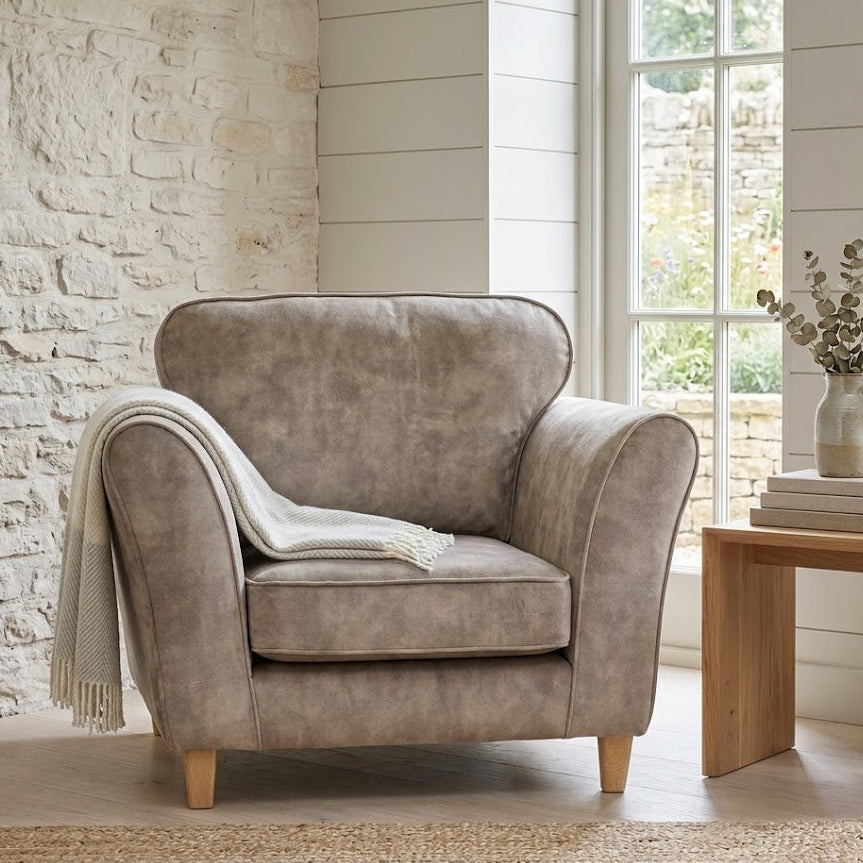 Brown armchair in a room with a stone wall and large window.