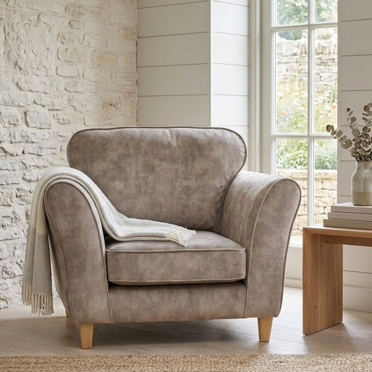 Brown armchair in a room with a stone wall and large window.