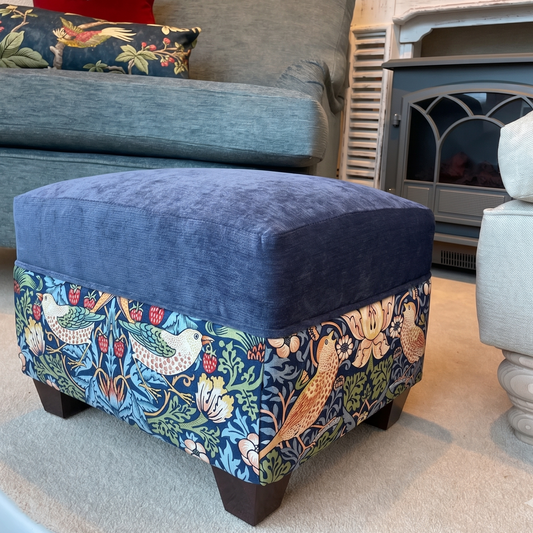 Blue ottoman with floral pattern in a living room setting